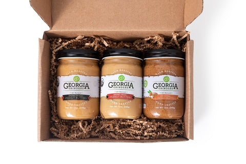 Three jars of Georgia's Best peanut butter in a cardboard box on a white background