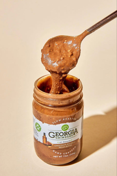Jar of Georgia Gingers chocolate almond butter with a spoonful on a beige background