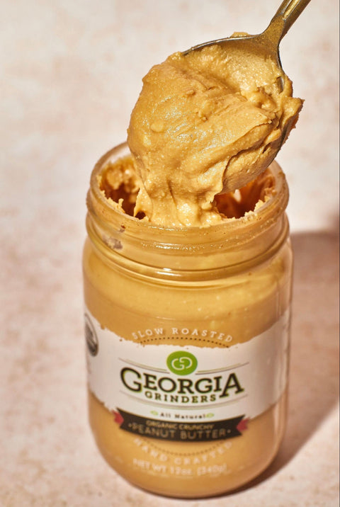 Jar of Georgia Grinders peanut butter with a spoonful on top