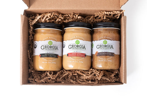 Three jars of Georgia's Best peanut butter in a cardboard box with brown filler