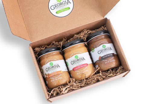 Three jars of Georgia Pecans peanut butter in a cardboard box with a visible brand logo.
